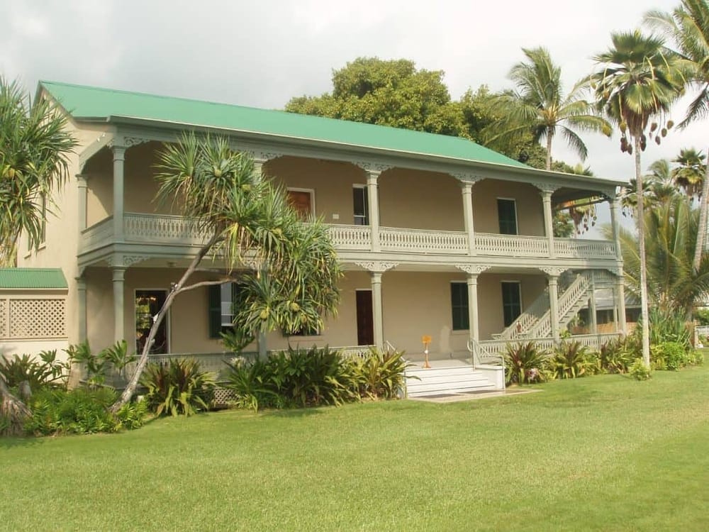 Spacious two-story tropical house with lush garden and palm trees, perfect for island living.