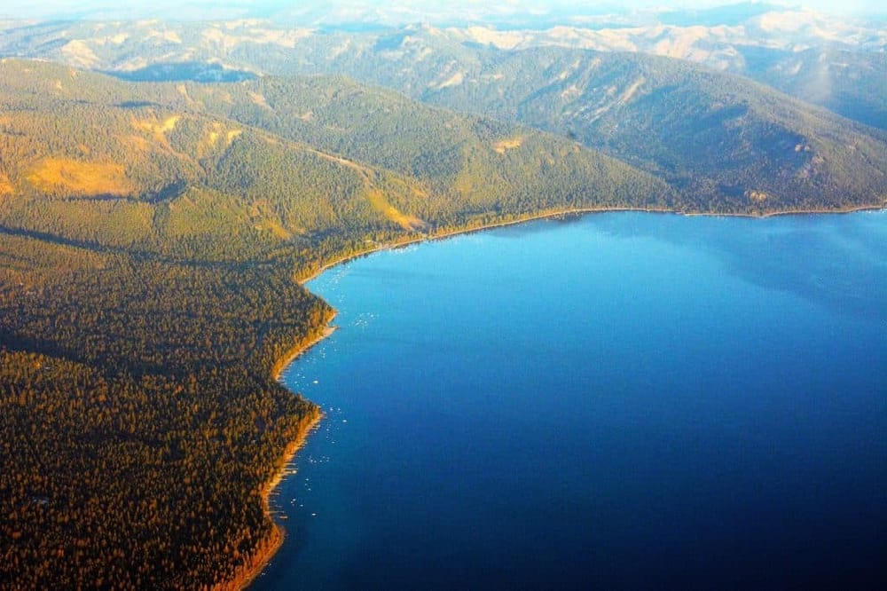 Serene mountain lake surrounded by lush forests, ideal for outdoor adventures and scenic exploration.