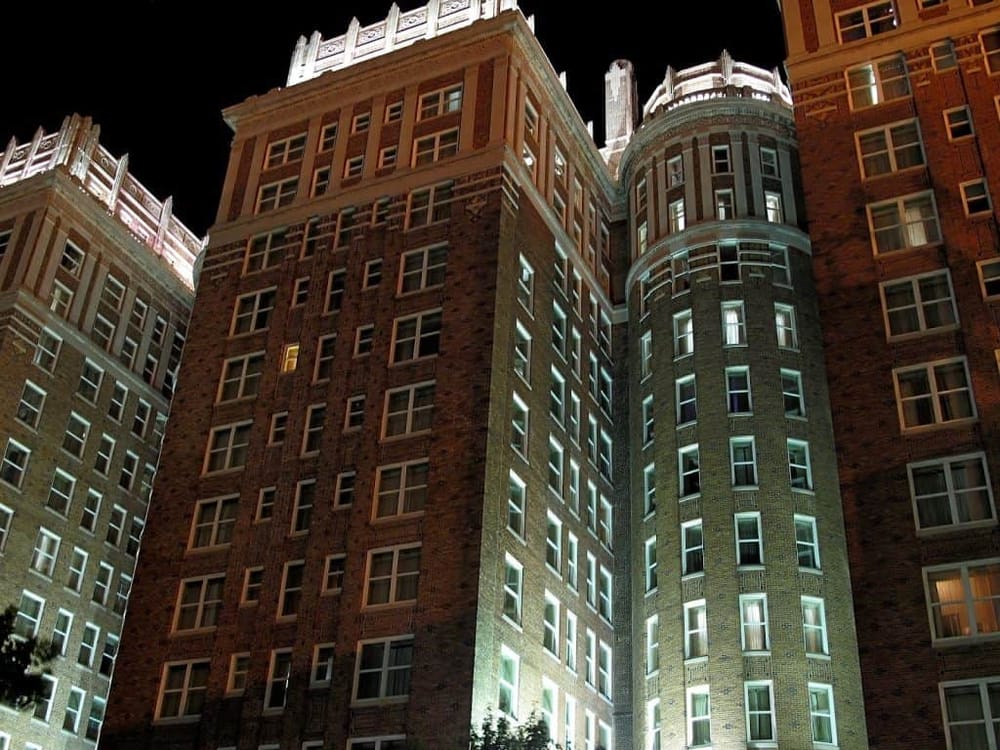 Elegant historic hotel building illuminated at night, showcasing classic architecture and city nightlife.