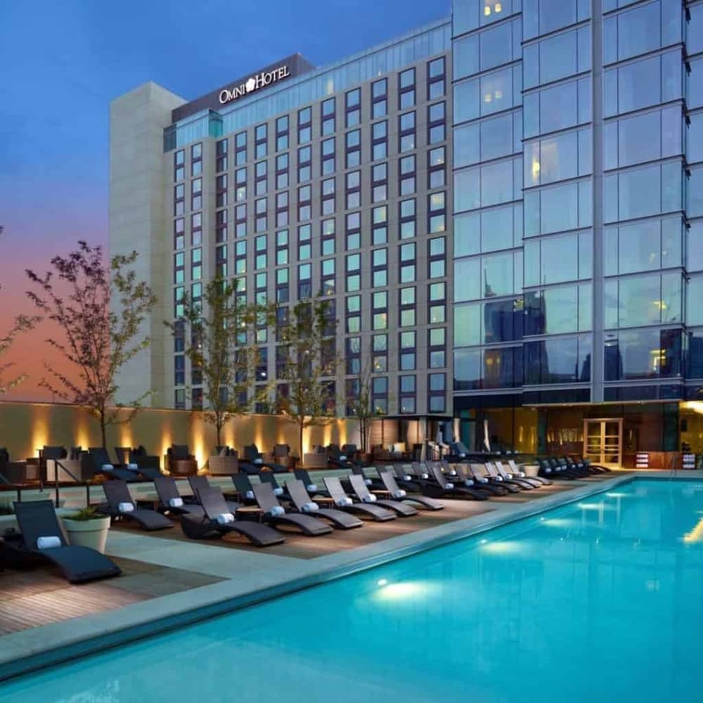 Modern hotel with outdoor pool and sun loungers at dusk, upscale accommodations near city center.