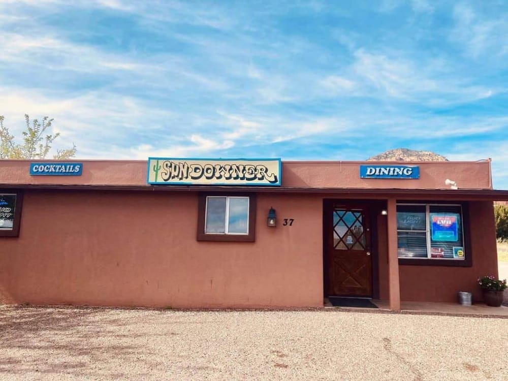 Colorful restaurant exterior with "Quest For Directions" signage, serving cocktails and dining options.