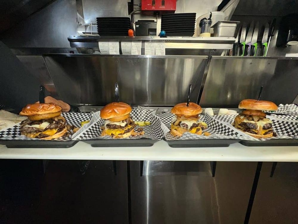 Succulent gourmet cheeseburgers with melted cheese and fresh toppings ready for order.