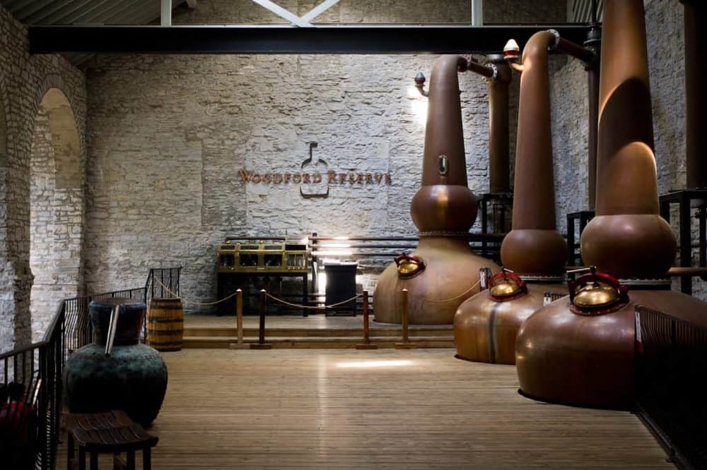 Vintage distillery equipment at Woodford Reserve bourbon distillery in Kentucky, showcasing copper stills and historic brick walls.