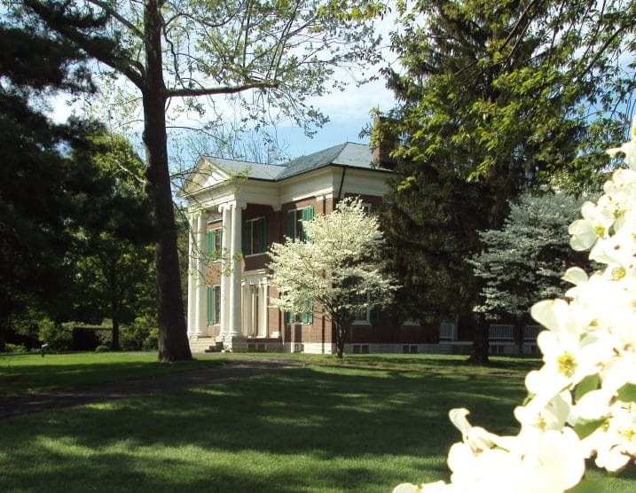 Ornate historic mansion surrounded by lush greenery and blooming trees, perfect for career counseling and personal growth.