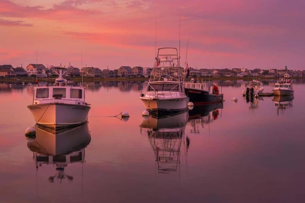 Serene harbor with boats during sunset, perfect for navigation and fishing trips.