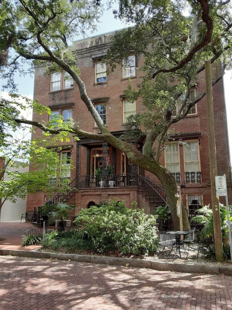 Charming brick building with a large tree and outdoor seating, highlighting guided navigation and direction services.
