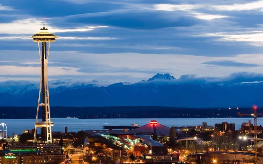 Seattle skyline with Space Needle and Mount Rainier in the background, showcasing city view and navigation services.