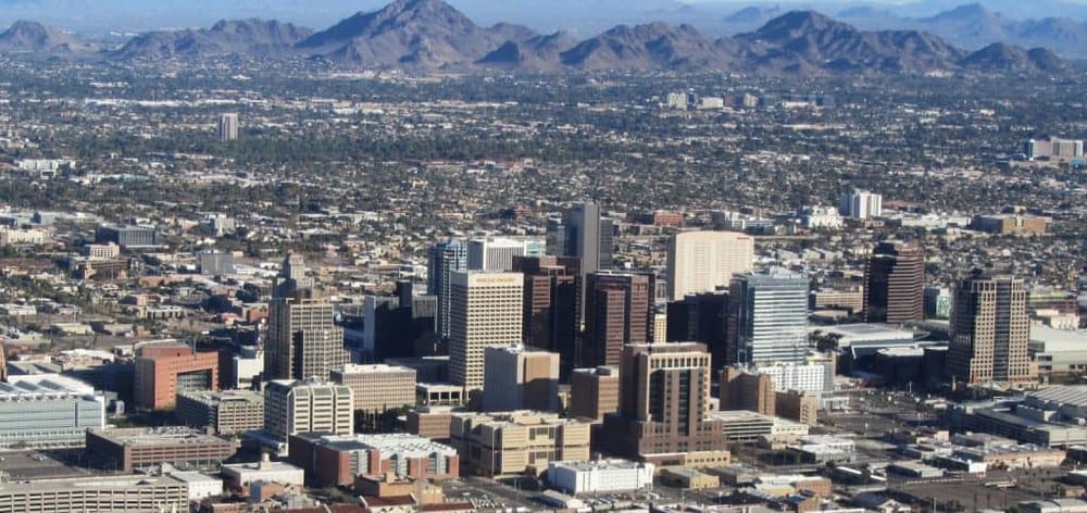 Aerial view of downtown Los Angeles with skyscrapers and mountains in the background, showcasing cityscape and urban landscape.