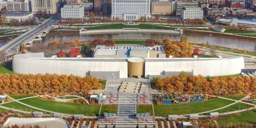 Modern cityscape with QuestForDirections cultural center and scenic river views in downtown.