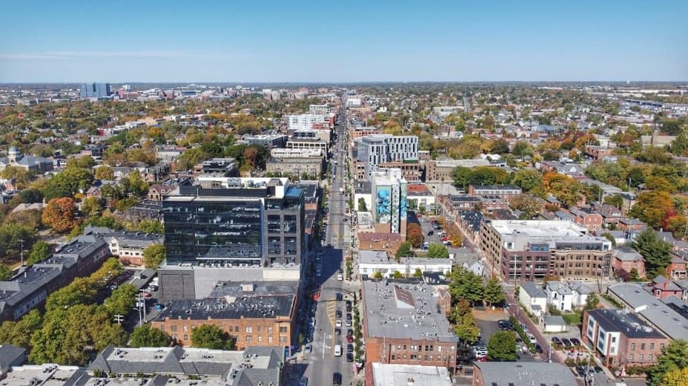 Aerial view of a city downtown area showcasing urban architecture and tree-lined streets.