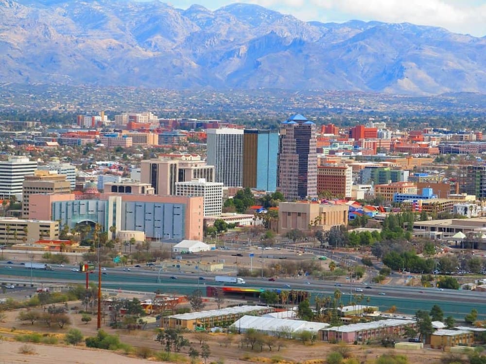 Vibrant downtown skyline of Tucson, Arizona with mountain range in background.