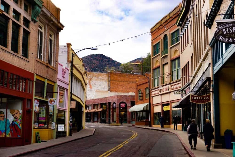 Colorful downtown street with shops and mountains in background, perfect for exploring travel destinations.