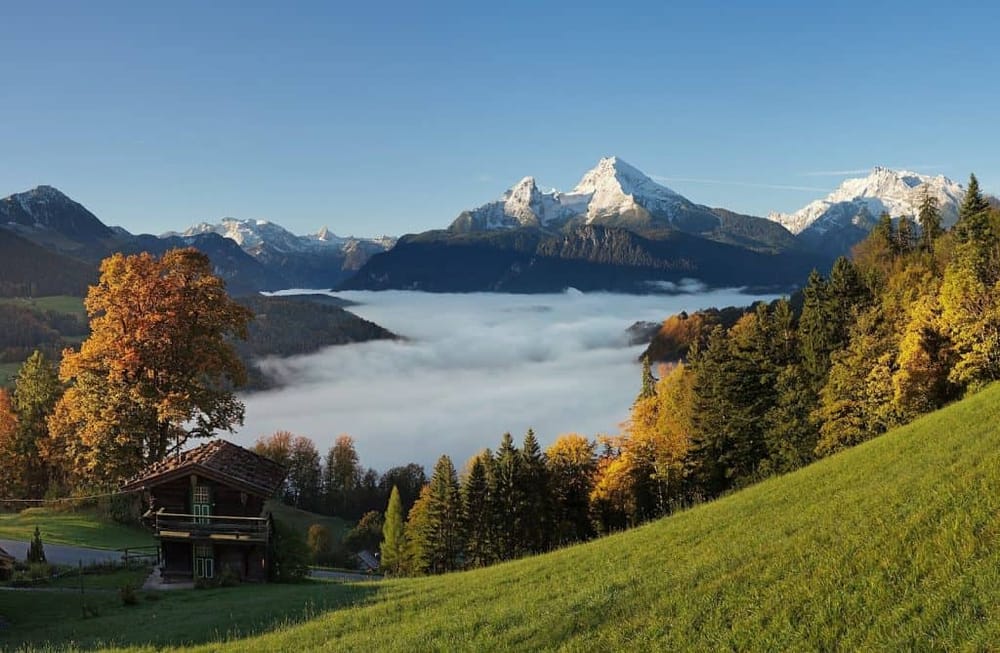 Breathtaking mountain landscape with snow-capped peaks and autumn foliage in Switzerland.