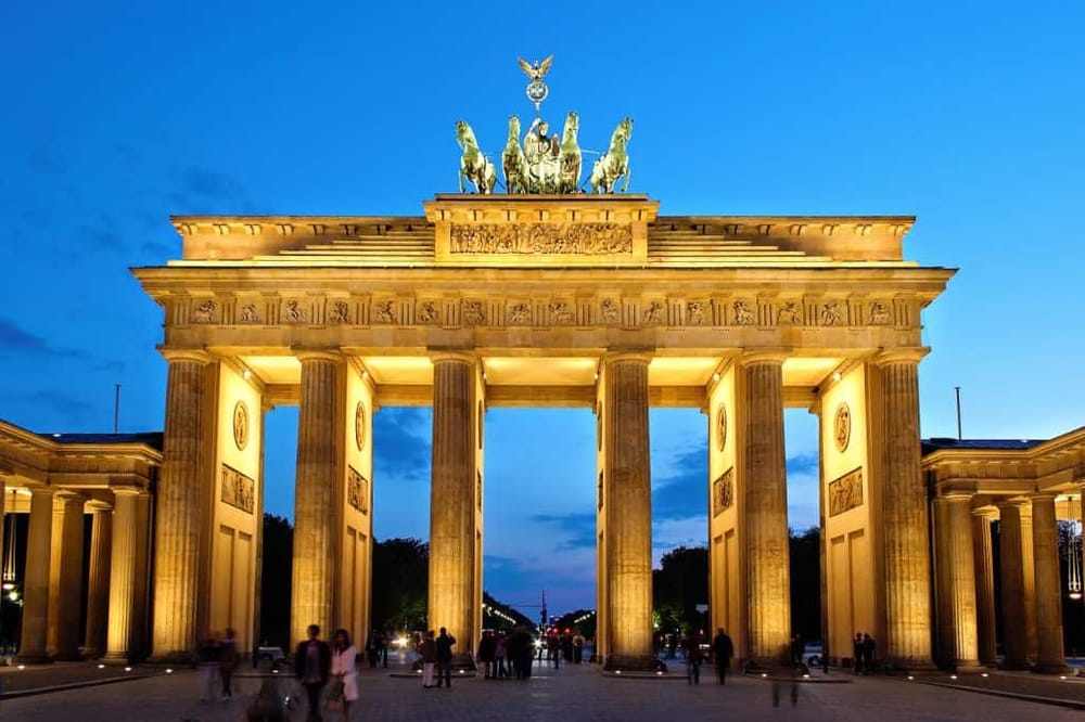 Majestic illuminated Brandenburg Gate in Berlin at dusk, iconic historic landmark, popular tourist attraction, and symbol of unity.