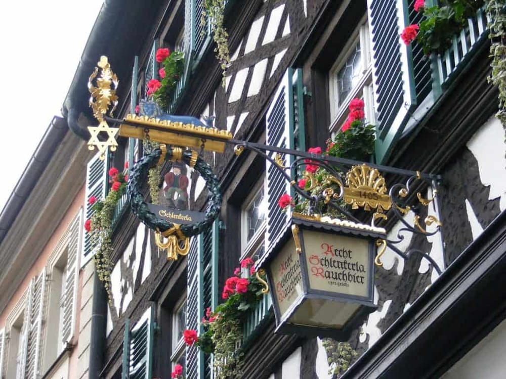 Traditional German Fachwerk House with Hanging Sign and Flower Boxes, Hessen, Germany.