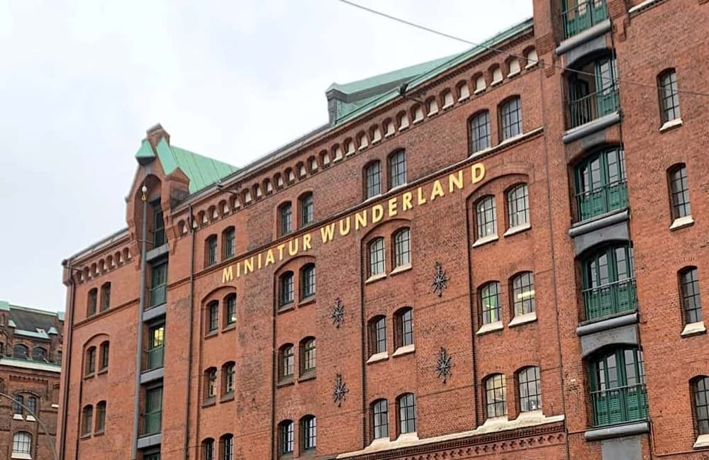 Vintage brick building with "Miniatur Wunderland" sign, popular tourist attraction in Hamburg, Germany.