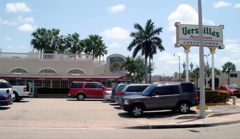 Vintage Florida restaurant with palm trees and parking lot.