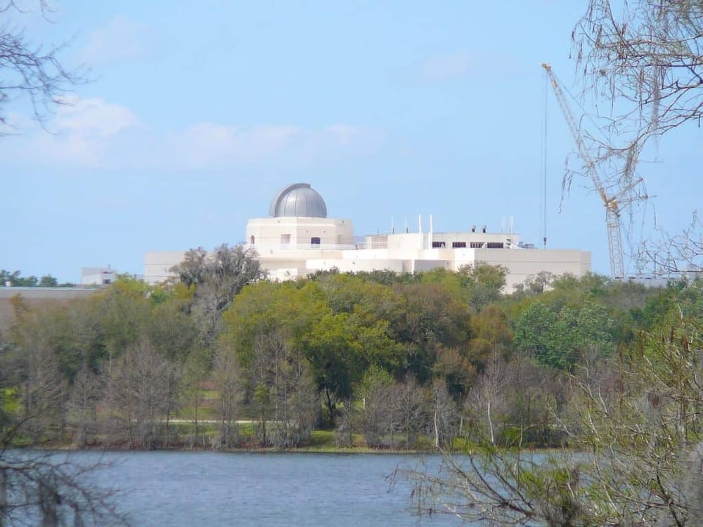 Observatory on the lake with trees and blue sky, GPS navigation and outdoor exploration focus.