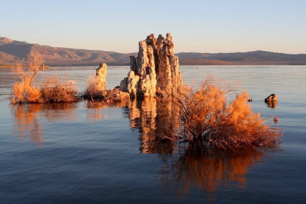 Weathered Tufa Rock formations at Mono Lake, California, with desert landscape in the background.