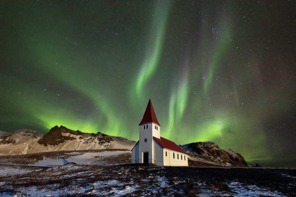 Aurora borealis over a small church in Iceland during winter night.
