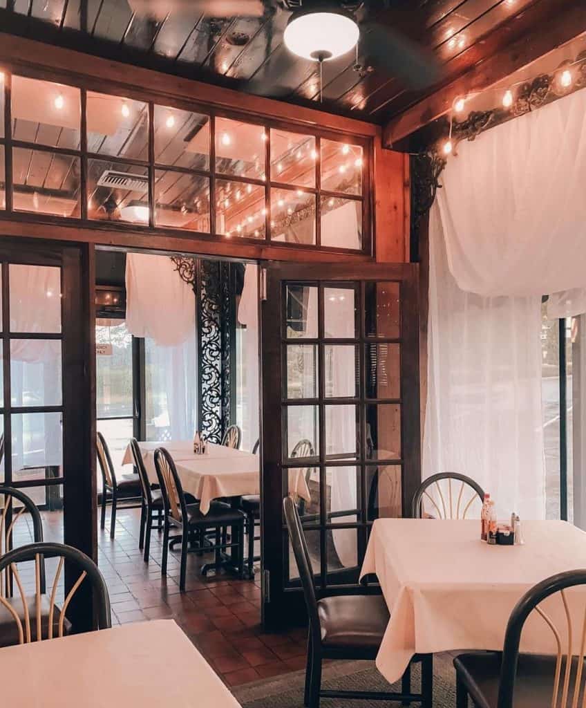 Cozy restaurant interior with wooden accents and string lights, perfect for dining and gatherings.