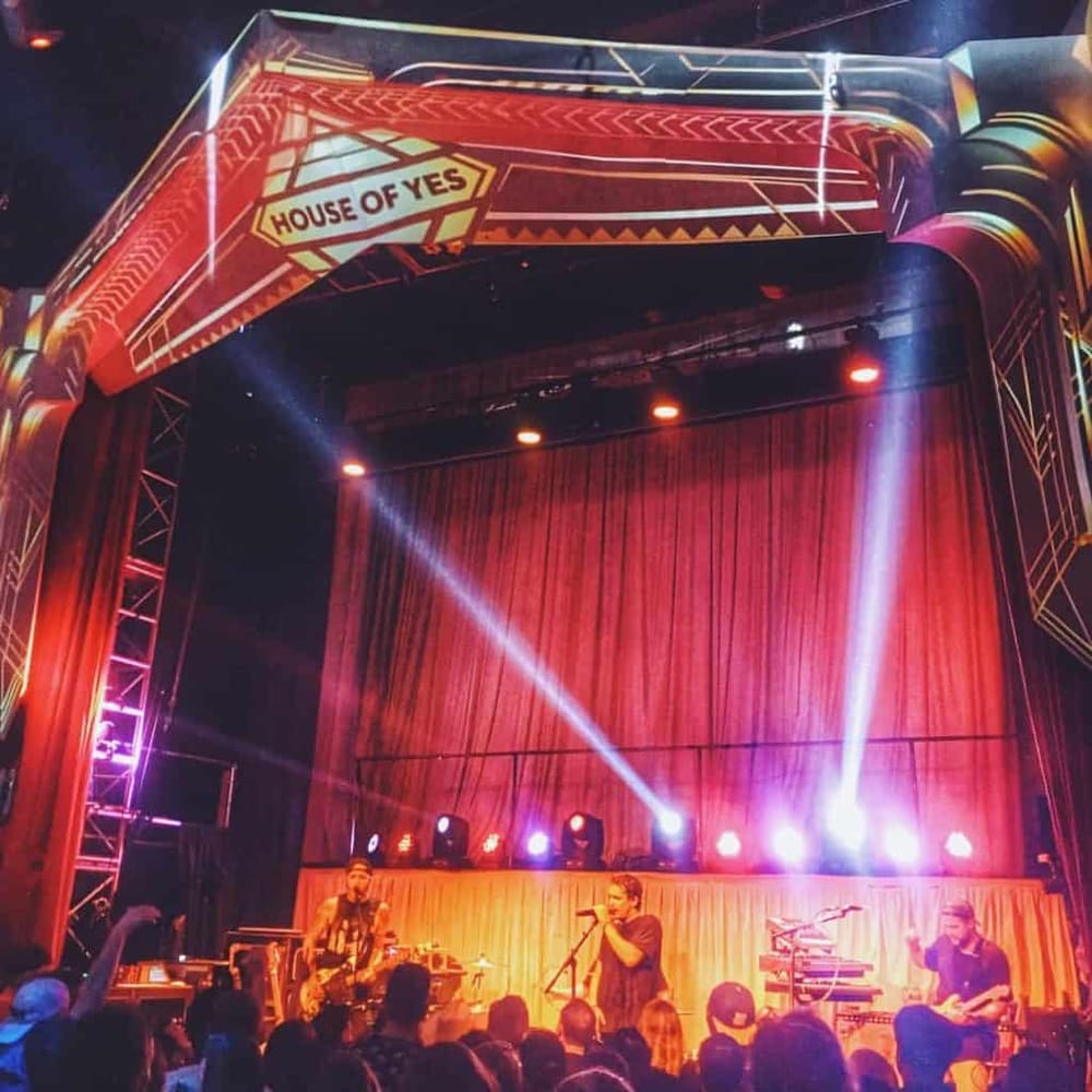 Vibrant concert stage with performers and dynamic lighting at QuestForDirections venue.