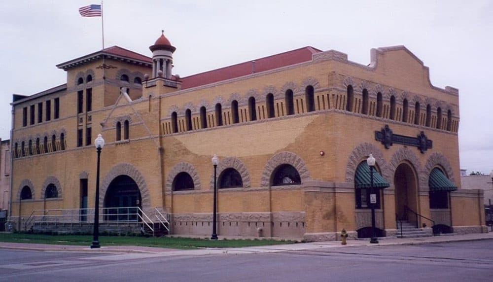 Historical courthouse building with brick architecture and American flag in small town.