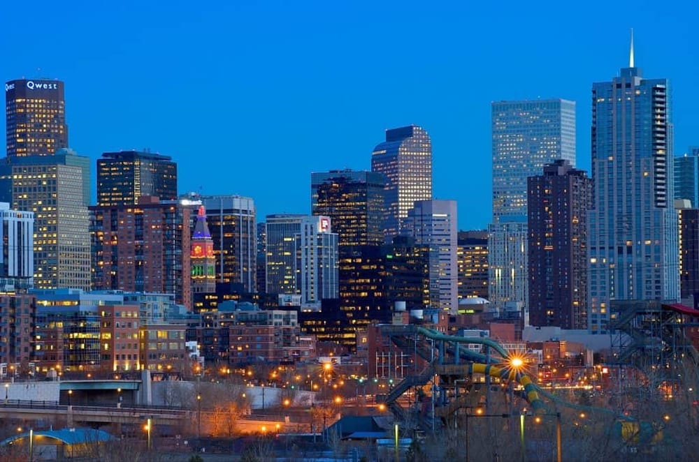 Vibrant city skyline with illuminated skyscrapers at dusk in downtown Dallas, TX.