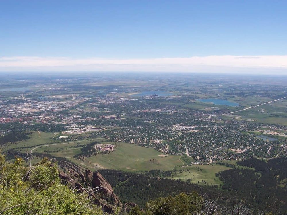 Aerial view of cityscape and green landscape from high mountain viewpoint in Colorado.