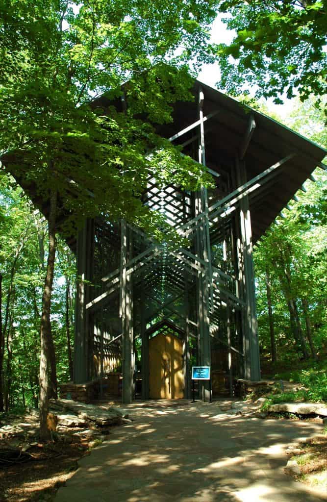Wooden observation tower in lush green forest for nature and outdoor exploration.