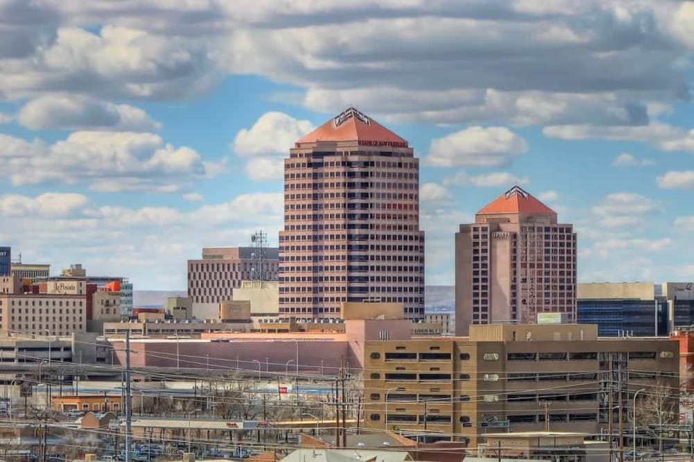 Modern downtown city skyline with prominent high-rise buildings and blue sky.