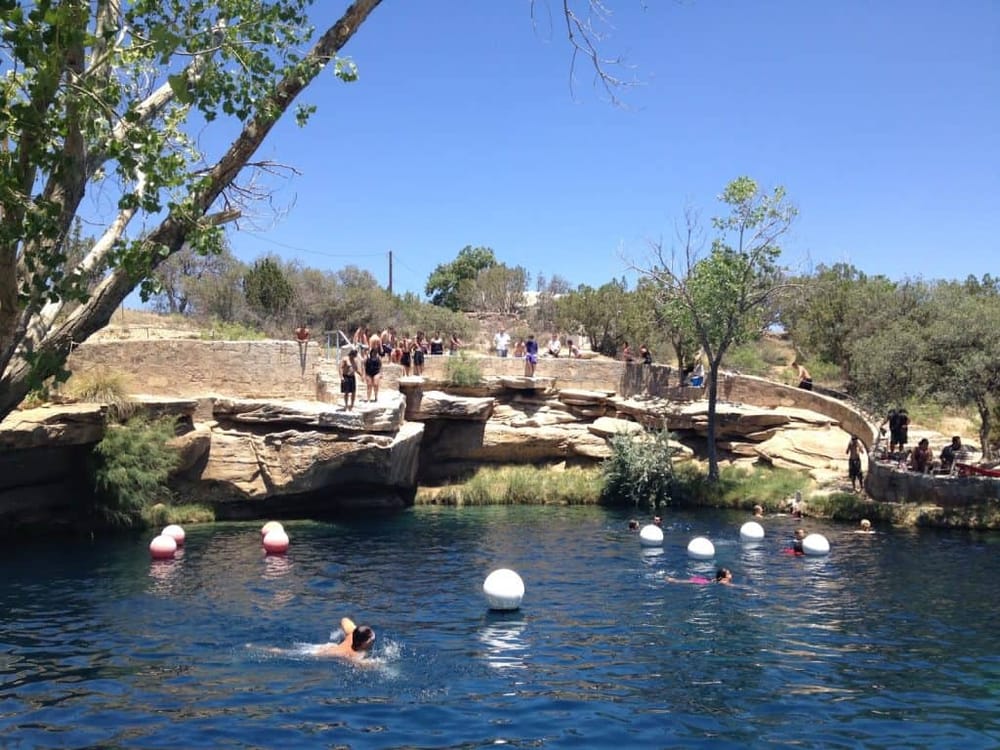 Freshwater swimming at popular natural swimming hole with rocks and trees, perfect for outdoor recreation and relaxation.