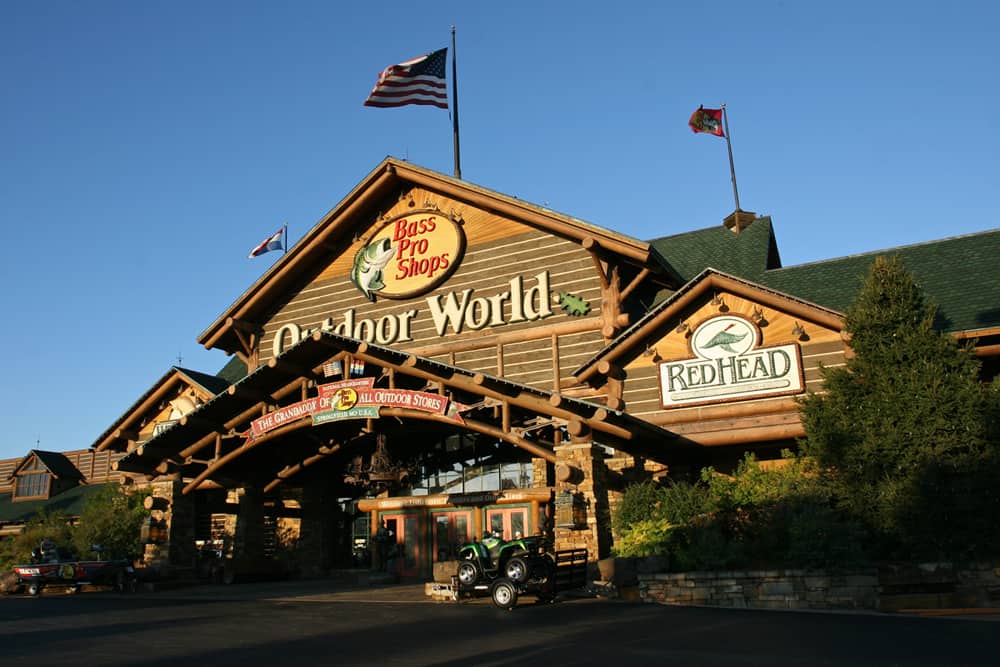 Huge Bass Pro Shops outdoor retailer at outdoor world with flags in clear blue sky.