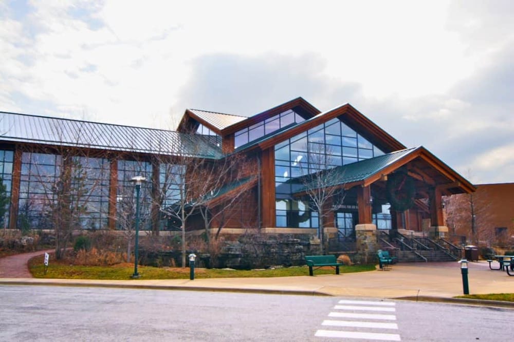 Modern building with large glass windows and wooden accents, looks like a community or visitor center.