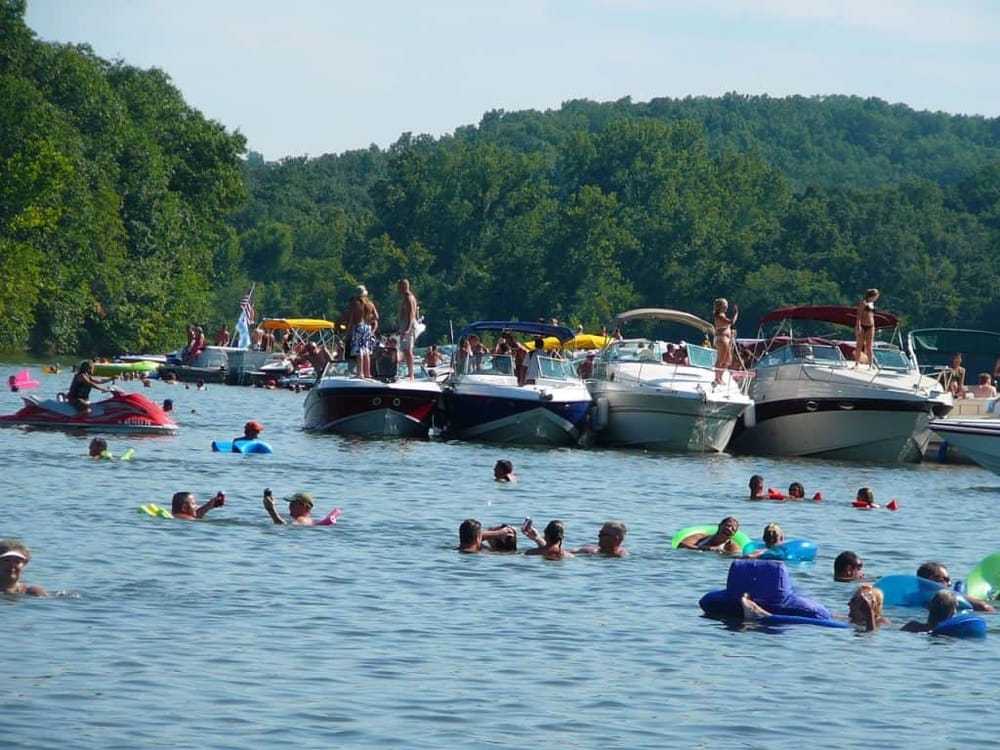 Boats and people enjoying a lively summer day on the water at Quest For Directions lake.