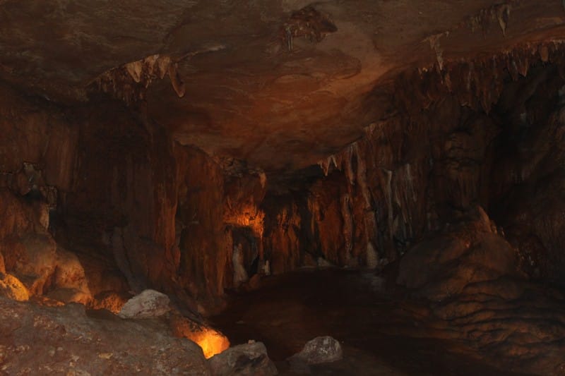 Ancient cave with stalactites and stalagmites inside a dark underground cavern.
