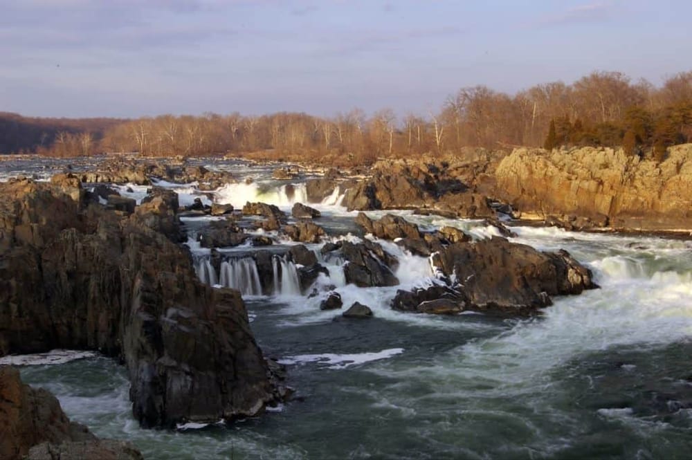 Vibrant river rapids with cascading waterfalls and rocky banks, perfect for outdoor adventure and nature exploration.