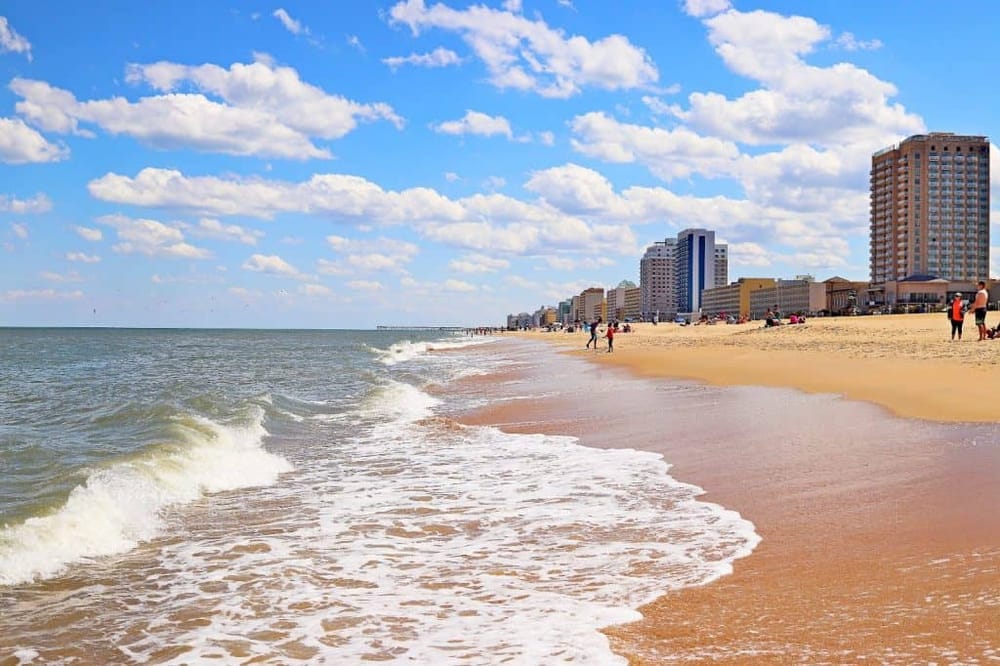Vibrant beach with high-rise buildings and clear blue sky, perfect for vacation and seaside relaxation.