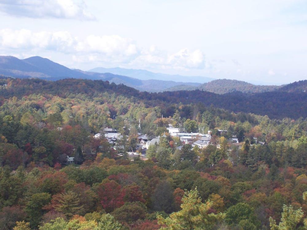 Colorful mountain village surrounded by autumn foliage and scenic mountain views.