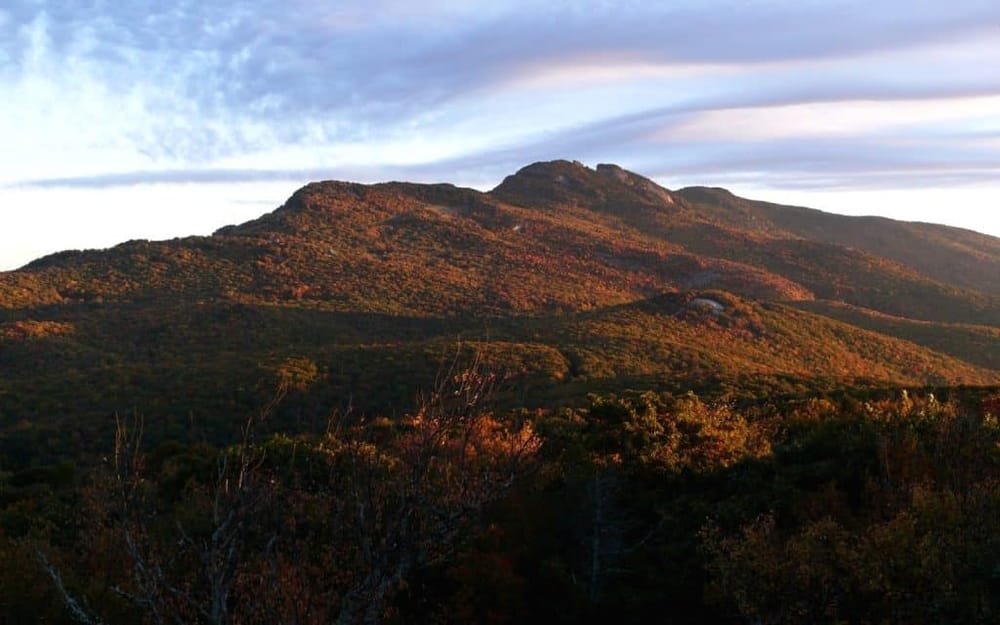 Colorful mountain landscape during autumn sunset, scenic hiking destination, fall foliage views.