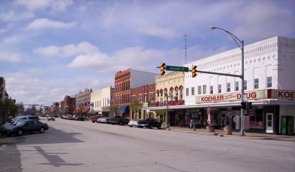 Colorful small-town street with historic buildings, storefronts, and traffic lights at Walker Street.