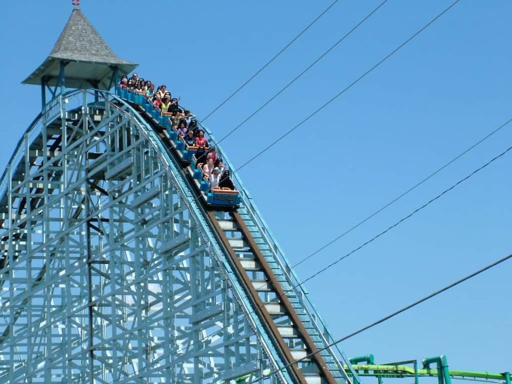 Thrilling roller coaster ride at QuestForDirections amusement park during sunny weather.