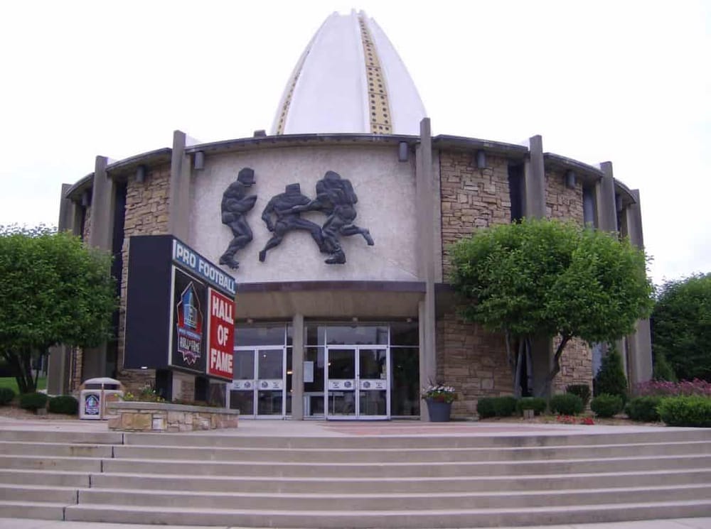 Historic football hall of fame building with sculptures and dedicated signage, welcoming football enthusiasts.