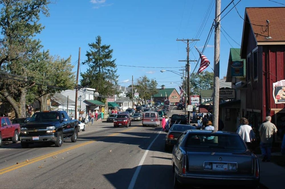 Charming small-town street scene with shops, cars, and pedestrians in downtown Quest for Directions.