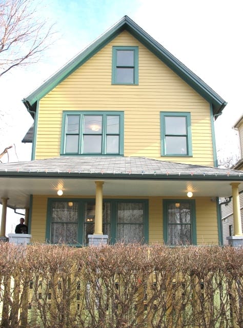 1. Bright yellow Victorian house with green trim and large windows, featuring a welcoming porch.