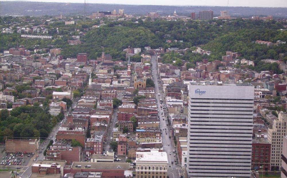 Aerial view of Knoxville, Tennessee cityscape with downtown skyline and green hillside backgrounds.