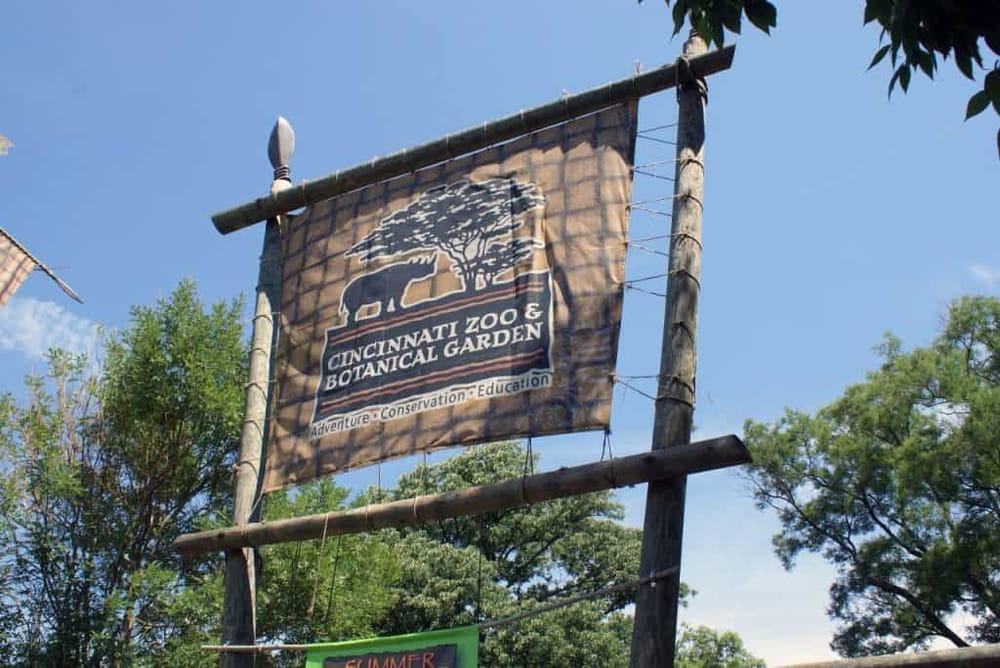 Cincinnati Zoo & Botanical Garden sign with trees and blue sky in the background.