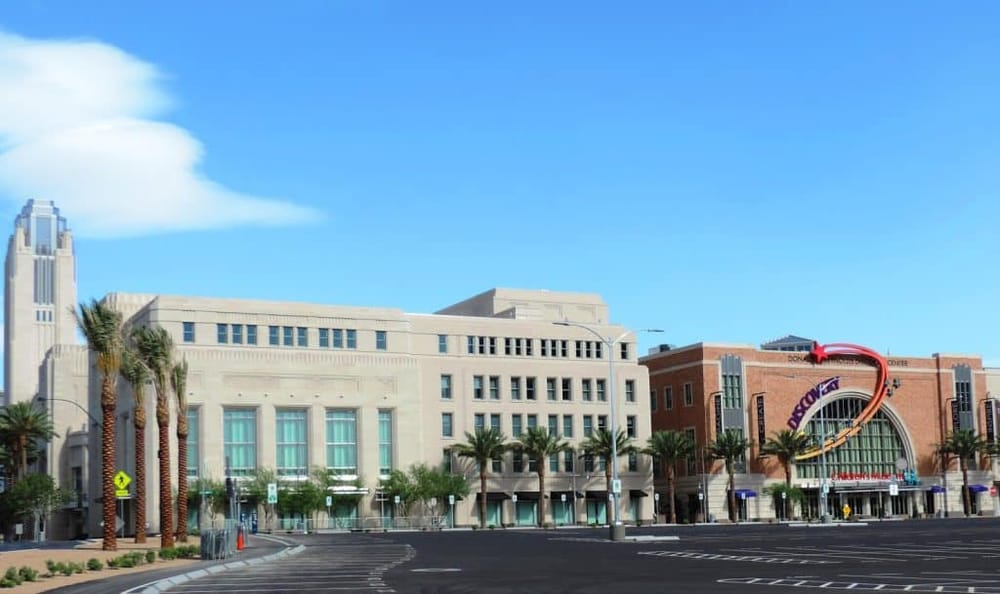 Modern urban building exterior with palm trees and clear blue sky at QuestForDirections.