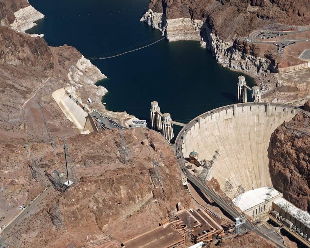 Reservoir at Hoover Dam with hydroelectric power plant and surrounding desert landscape.