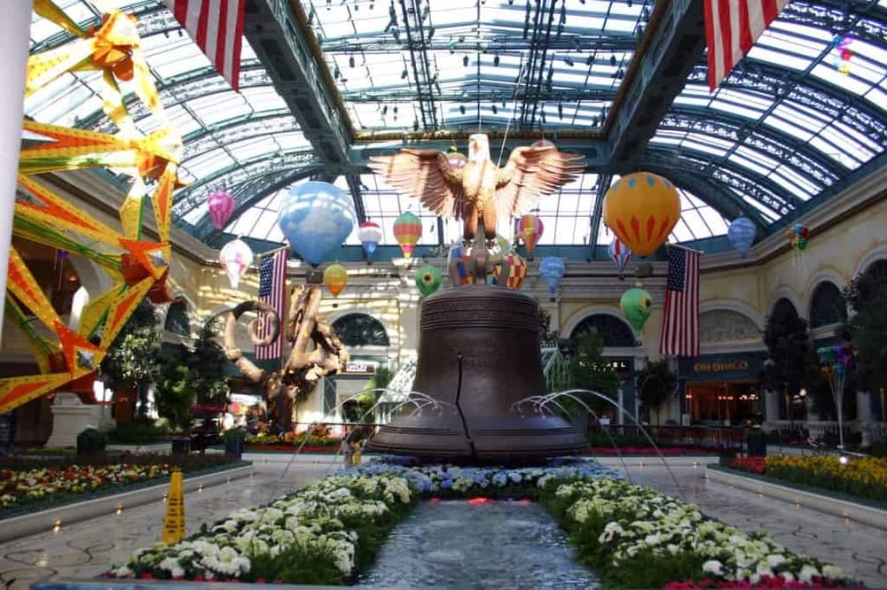 Colorful indoor shopping mall with large Liberty Bell replica and hot air balloon decorations.